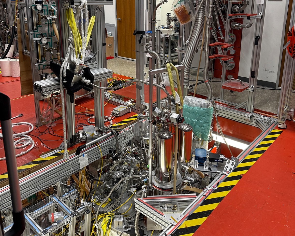 Northwestern University positron-trap apparatus recessed into a laboratory floor, surrounded by metal tubing, cables and support frames.