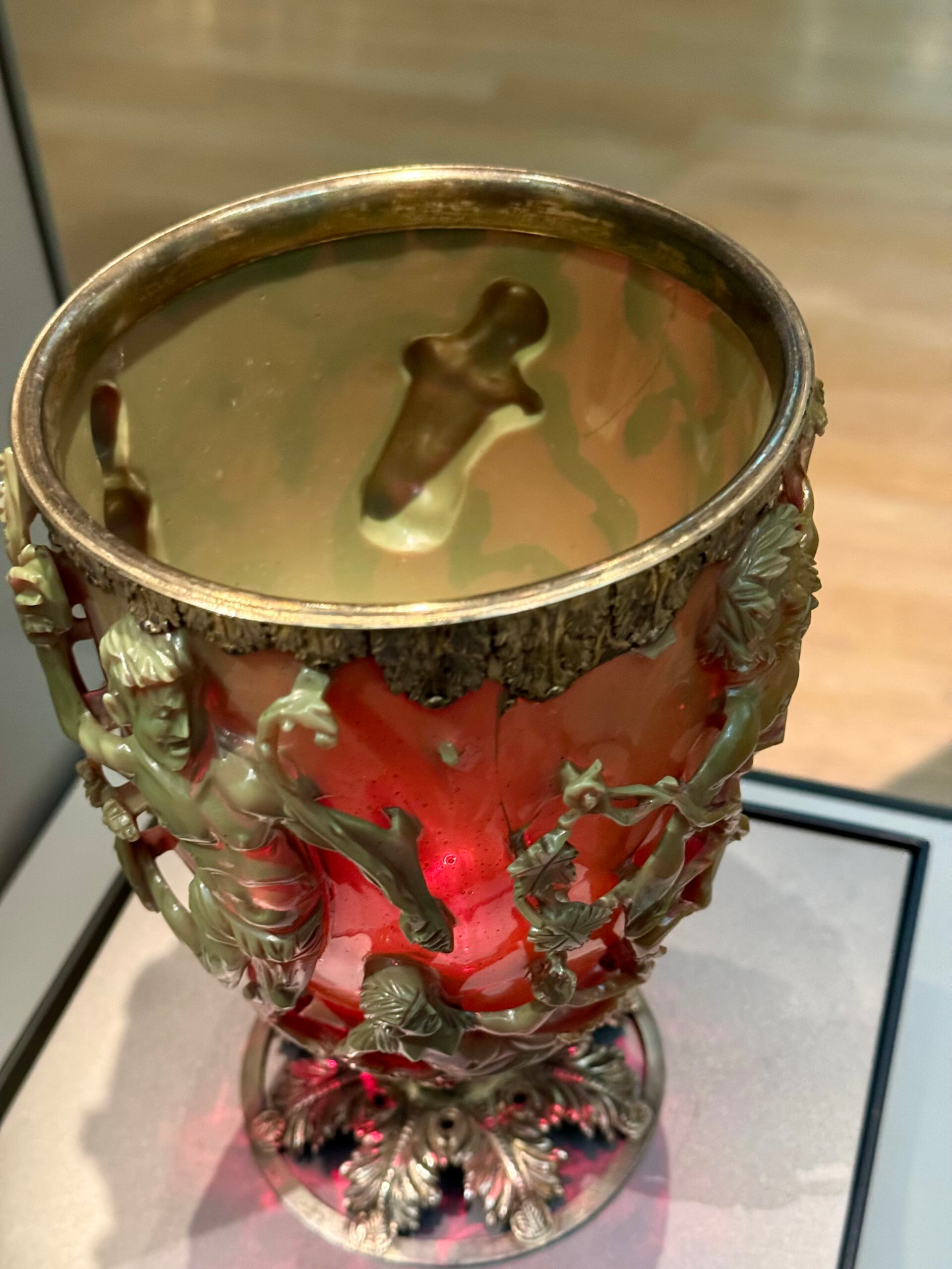 The ancient Lycurgus Cup viewed from above, with green carved figures surrounding ruby-red glass at the British Museum
