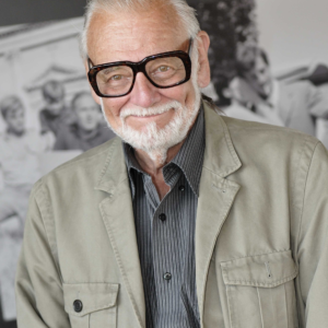George A. Romero wearing glasses and a light jacket at the 2009 Venice Film Festival.