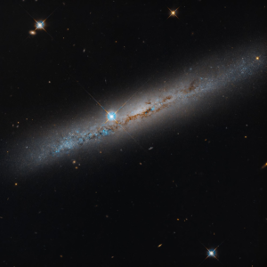 Hubble image of the edge-on spiral galaxy NGC 1827, with a rusty dust lane crossing its bright disk