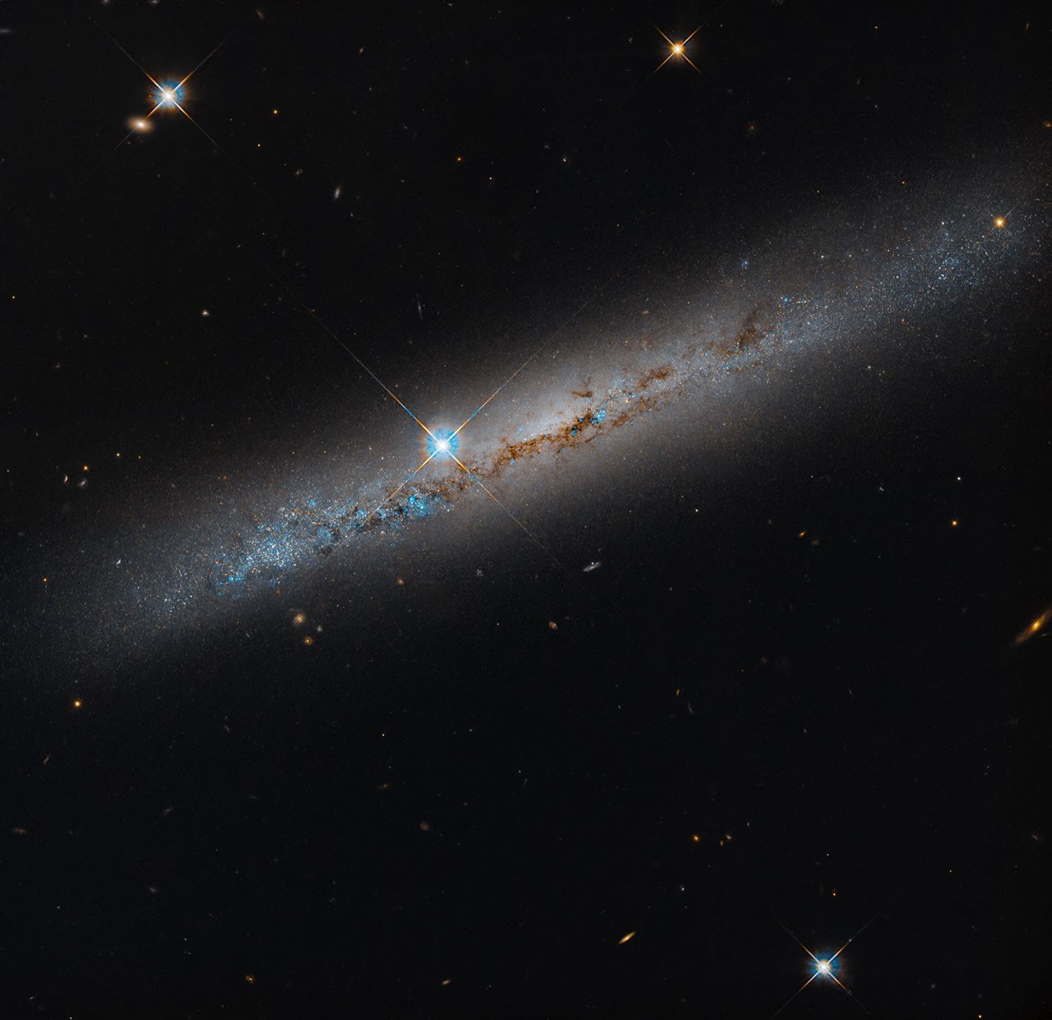 Hubble image of the edge-on spiral galaxy NGC 1827, with a rusty dust lane crossing its bright disk